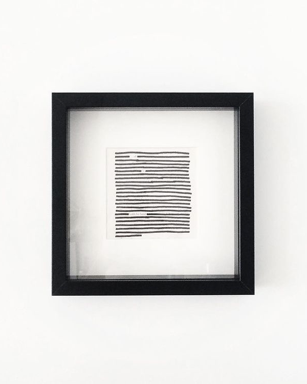 Framed black and white abstract art piece with Blackout Poetry on a white background