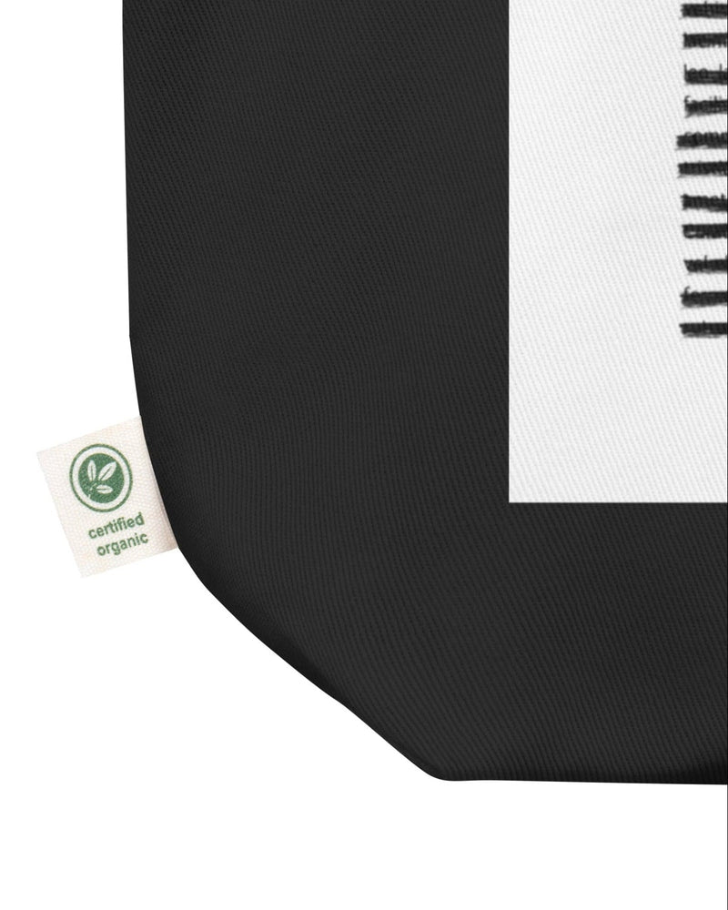 Product mockup - Closeup Of Sustainable Black Tote Bag with Blackout Poetry Print Tag